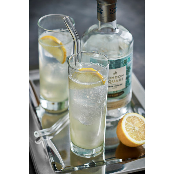 two glasses of Tom Collins cocktail and a bottle of London Square Premium London Dry Gin on a silver tray